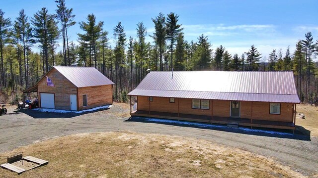 476 N Rd, Medford, ME 04463 - view of front facade with a detached garage, a view of trees, an outbuilding, and metal roof