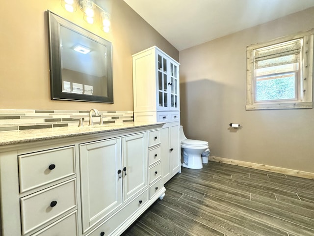 476 N Rd, Medford, ME 04463 - bathroom featuring vanity, wood finished floors, toilet, baseboards, and tasteful backsplash