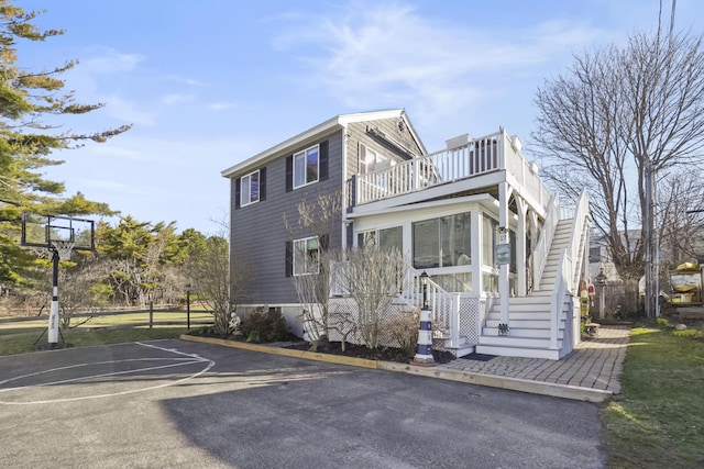 view of property exterior with uncovered parking and a balcony