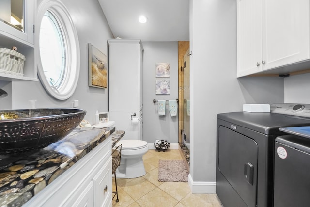 full bath with toilet, washing machine and dryer, a stall shower, tile patterned flooring, and vanity