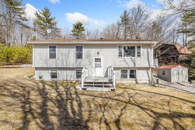 back of house featuring a storage shed, a yard, fence, and an outdoor structure