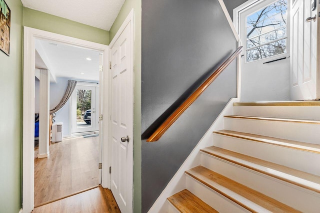 stairs with recessed lighting and wood finished floors