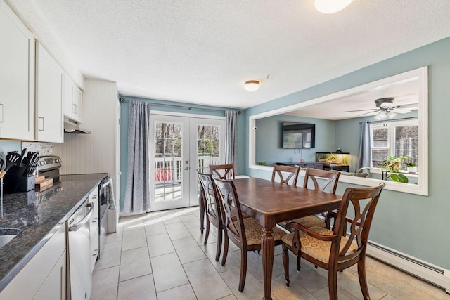 dining room with french doors, a wealth of natural light, a textured ceiling, and a baseboard radiator