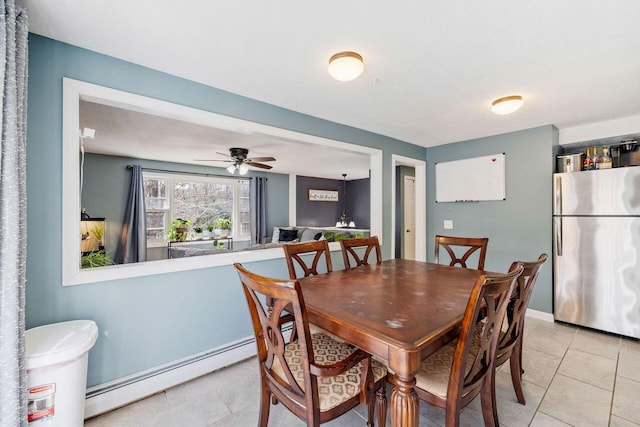 dining room with a baseboard heating unit, a ceiling fan, and light tile patterned flooring