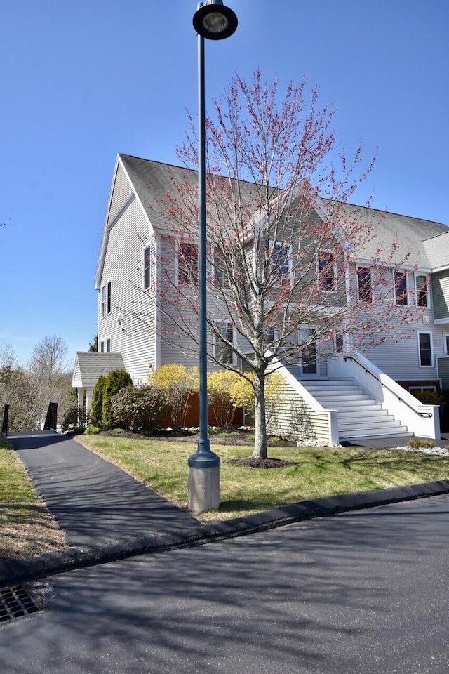 exterior space featuring a front yard and stairs