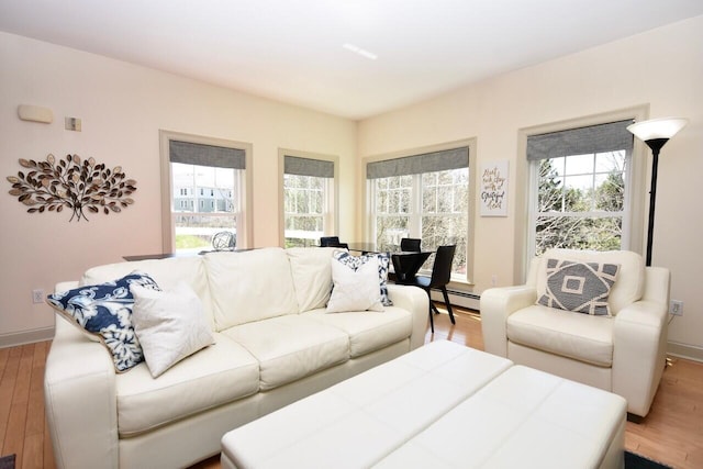 living room with light wood-style floors, baseboards, and baseboard heating
