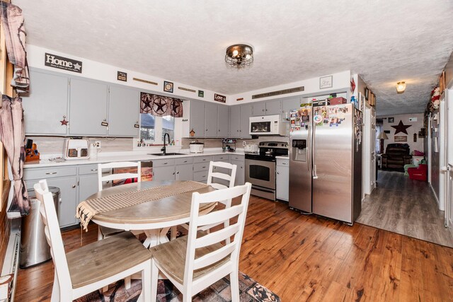 44 Sunset Ave, Wilton, ME 04294 - kitchen with gray cabinetry, hardwood / wood-style flooring, a sink, and stainless steel appliances