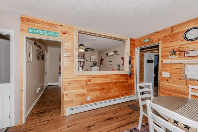 44 Sunset Ave, Wilton, ME 04294 - dining space featuring baseboard heating, wood walls, wood finished floors, and ceiling fan