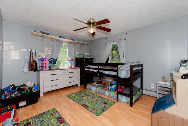 44 Sunset Ave, Wilton, ME 04294 - bedroom with a baseboard heating unit, a ceiling fan, a textured ceiling, and light wood-style floors