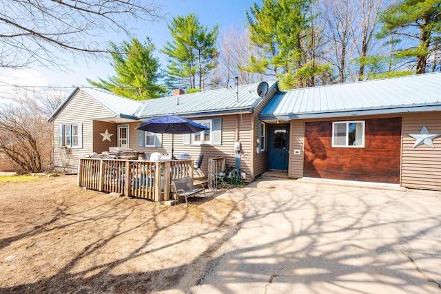 44 Sunset Ave, Wilton, ME 04294 - back of property featuring a chimney, a wooden deck, and metal roof