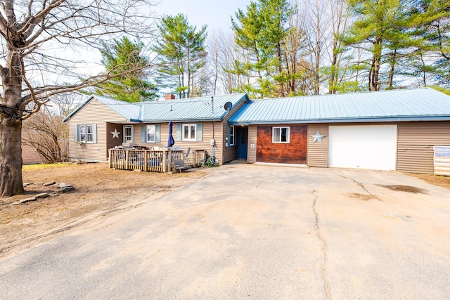 44 Sunset Ave, Wilton, ME 04294 - ranch-style home with a chimney, metal roof, a wooden deck, concrete driveway, and an attached garage
