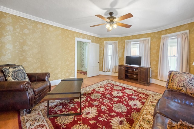 living area with light wood-style floors, ceiling fan, and crown molding