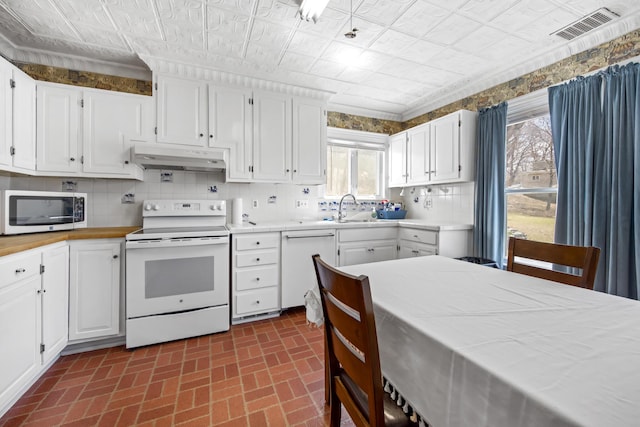 kitchen with white appliances, light countertops, an ornate ceiling, under cabinet range hood, and visible vents