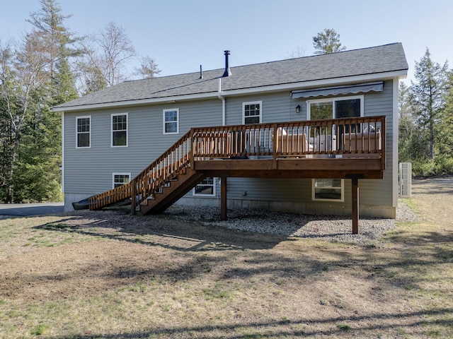 back of property with roof with shingles, a deck, and stairway