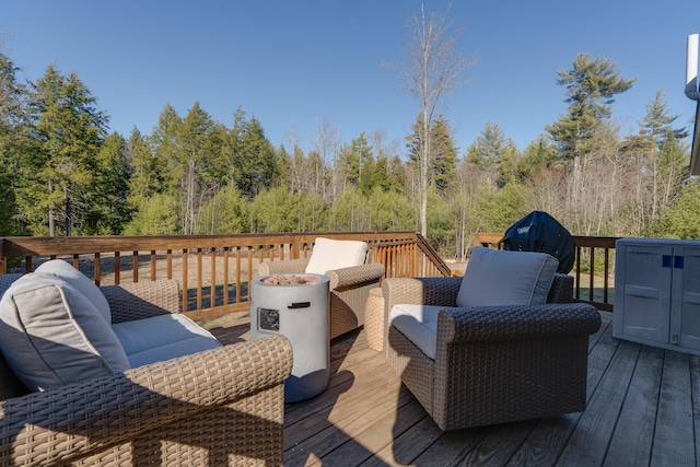 wooden terrace featuring a grill and an outdoor living space