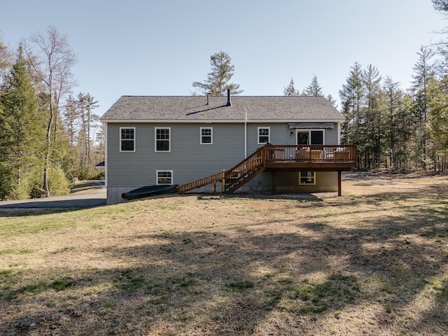 back of property featuring a lawn, roof with shingles, stairs, and a deck