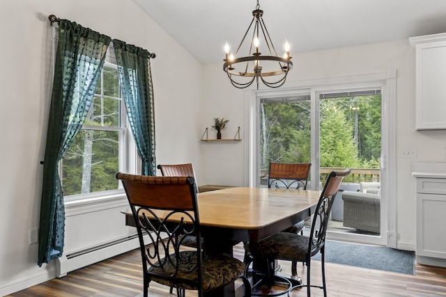 dining space with wood finished floors, a wealth of natural light, and a notable chandelier
