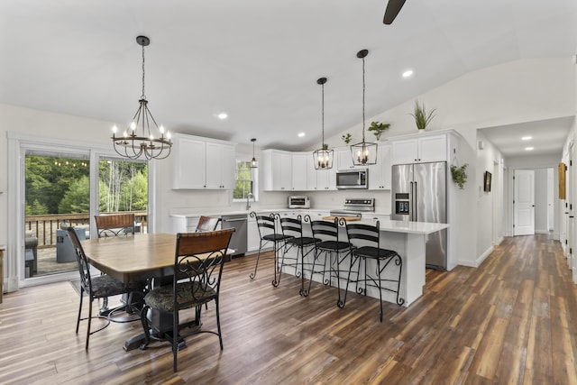 dining area with recessed lighting, lofted ceiling, a toaster, a chandelier, and dark wood-style flooring