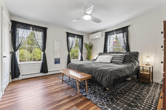 bedroom featuring a baseboard heating unit, a ceiling fan, wood finished floors, and a wall unit AC