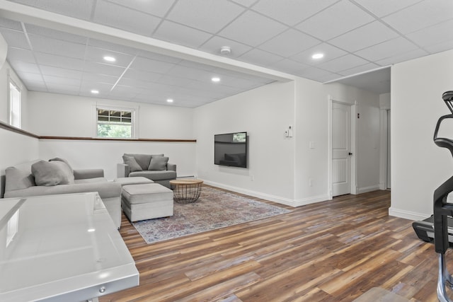 living area featuring wood finished floors, a drop ceiling, and recessed lighting