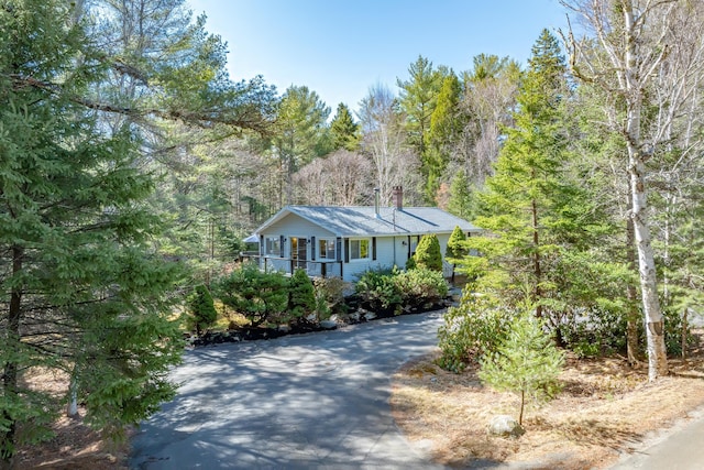 view of front of house with a forest view and covered porch