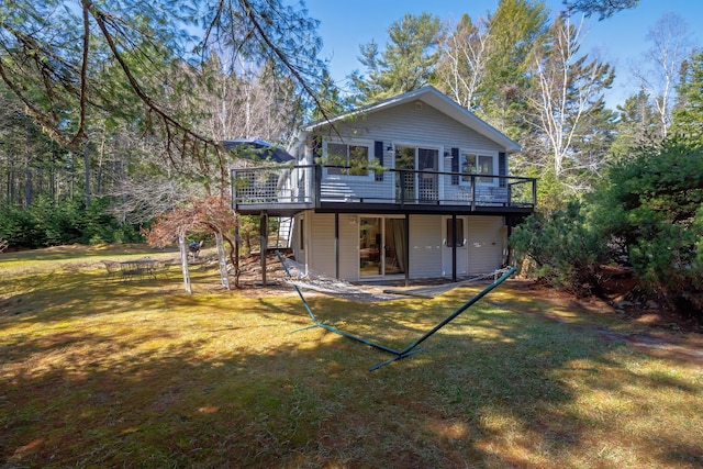 back of house with a wooden deck, a lawn, and stairway