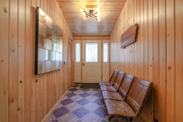 entryway featuring wooden walls and a chandelier