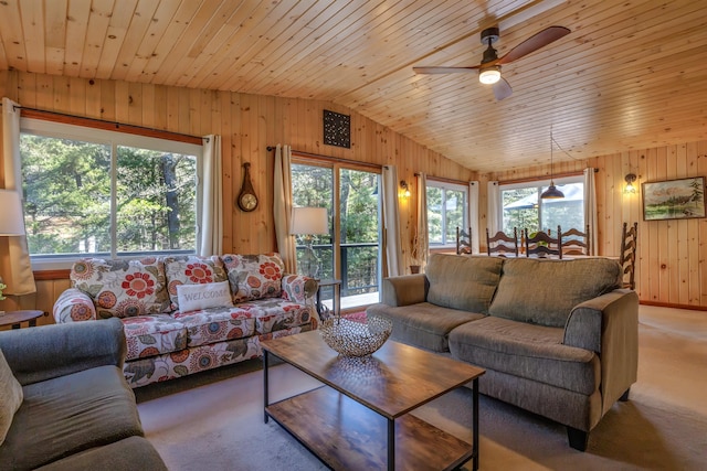 living area featuring lofted ceiling, wooden walls, carpet floors, and a ceiling fan