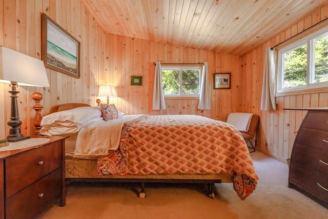 bedroom with lofted ceiling, wood walls, carpet, and multiple windows