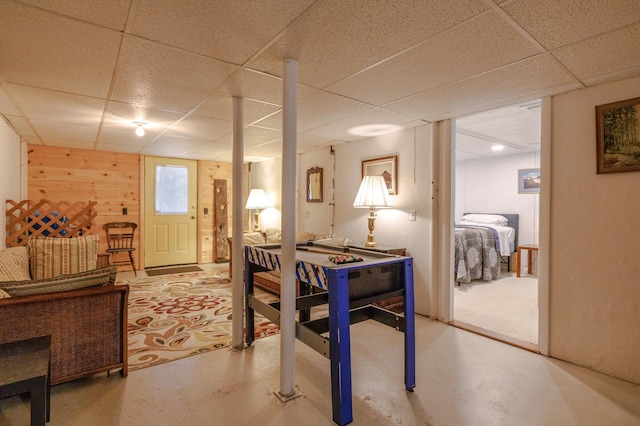 interior space featuring a paneled ceiling and finished concrete flooring