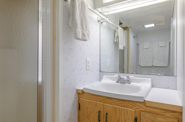 bathroom featuring walk in shower and vanity