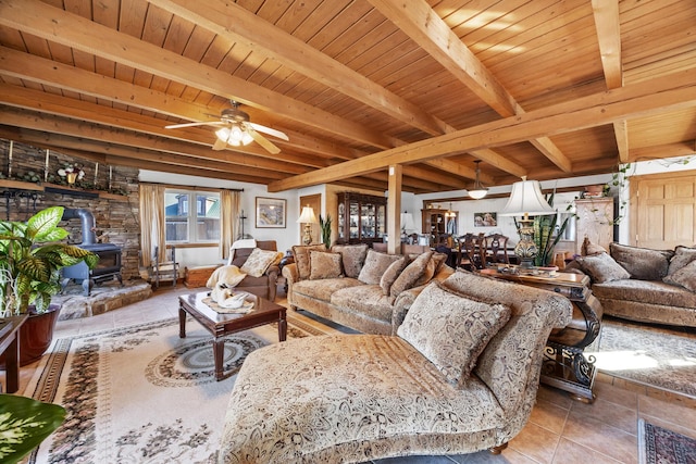54 Folsom Ridge Rd, Burlington, ME 04417 - tiled living area featuring beam ceiling, ceiling fan, a wood stove, and wood ceiling