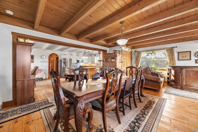54 Folsom Ridge Rd, Burlington, ME 04417 - dining room featuring light wood-style flooring, arched walkways, beam ceiling, and wood ceiling