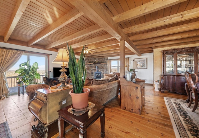 54 Folsom Ridge Rd, Burlington, ME 04417 - living room with beamed ceiling, a wood stove, and wooden ceiling