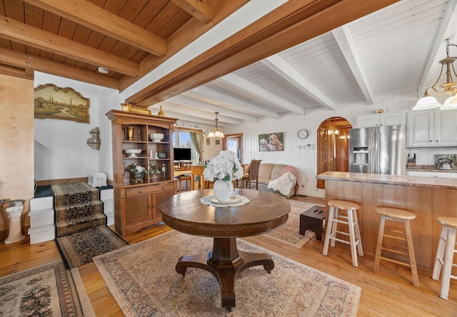 54 Folsom Ridge Rd, Burlington, ME 04417 - dining area featuring beamed ceiling, light wood-style flooring, arched walkways, and wooden ceiling