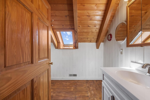 54 Folsom Ridge Rd, Burlington, ME 04417 - bathroom with a skylight, hardwood / wood-style floors, beamed ceiling, vanity, and visible vents