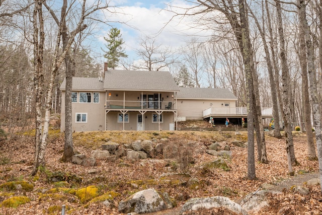 31 Pulpit Rock Rd, Raymond, ME 04071 - back of property with a wooden deck, a chimney, and roof with shingles