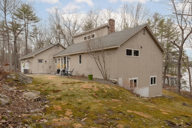 31 Pulpit Rock Rd, Raymond, ME 04071 - back of property with roof with shingles, a chimney, and a yard