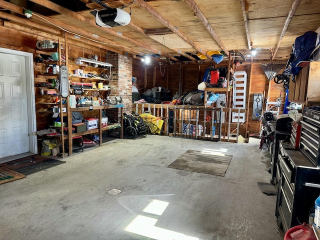 garage with wooden walls, a workshop area, and a garage door opener
