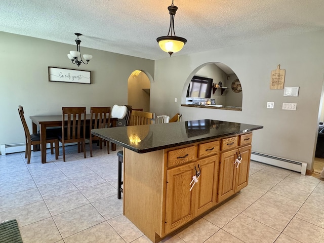 kitchen featuring baseboard heating, decorative light fixtures, a kitchen island, and light tile patterned floors