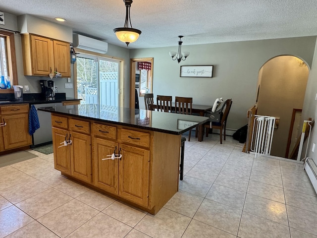kitchen featuring a wall mounted air conditioner, a center island, a textured ceiling, dishwasher, and arched walkways