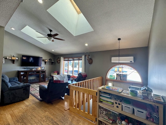 living room featuring wood-type flooring, a ceiling fan, and a textured ceiling