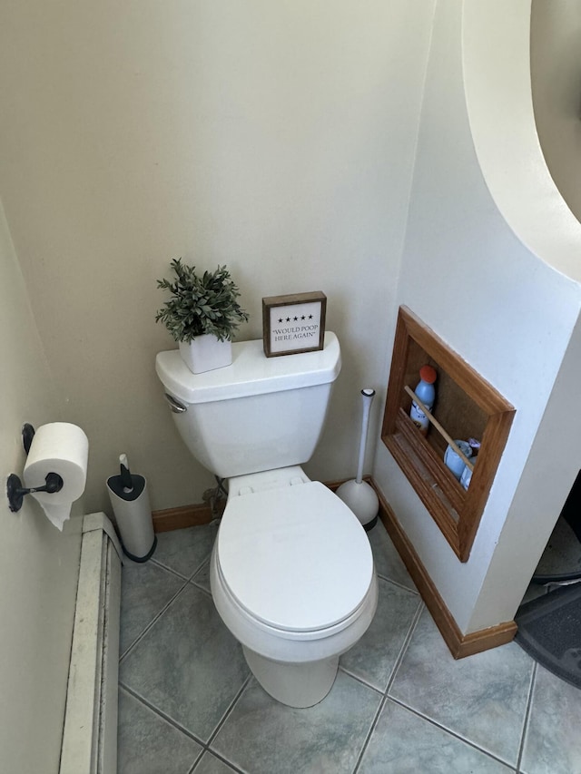 bathroom with toilet, tile patterned flooring, and baseboards