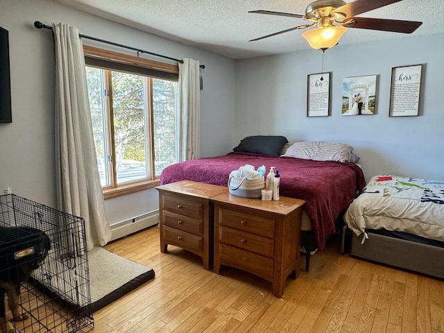 bedroom with baseboard heating, a textured ceiling, a ceiling fan, and light wood-style flooring