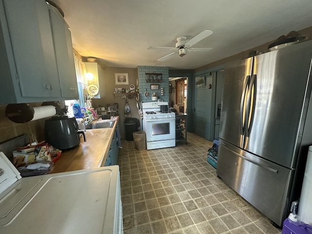 18 View St, Jonesport, ME 04649 - kitchen featuring freestanding refrigerator, white range with gas stovetop, a ceiling fan, washer / dryer, and a sink