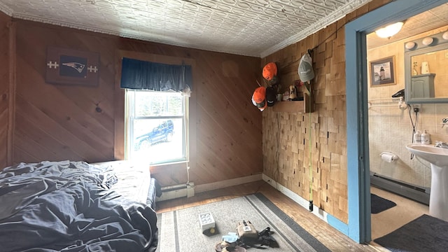 18 View St, Jonesport, ME 04649 - bedroom featuring a baseboard radiator, crown molding, baseboards, wooden walls, and wood finished floors