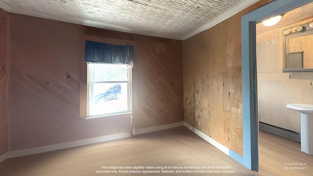 18 View St, Jonesport, ME 04649 - unfurnished room with baseboard heating, wooden walls, wood finished floors, crown molding, and baseboards