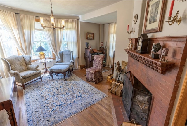 36 Cutler Rd, East Machias, ME 04630 - living area featuring a brick fireplace, a chandelier, and wood finished floors