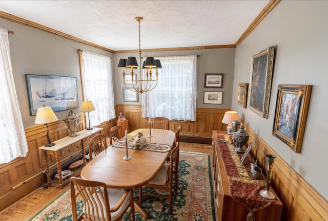 36 Cutler Rd, East Machias, ME 04630 - dining area featuring a wainscoted wall, ornamental molding, a chandelier, wood finished floors, and wood walls