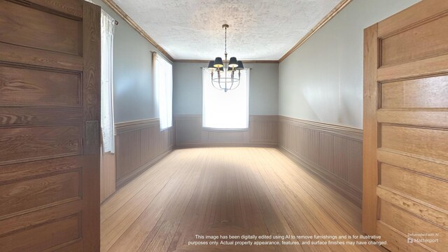 36 Cutler Rd, East Machias, ME 04630 - empty room featuring a chandelier, wainscoting, light wood-type flooring, crown molding, and a textured ceiling
